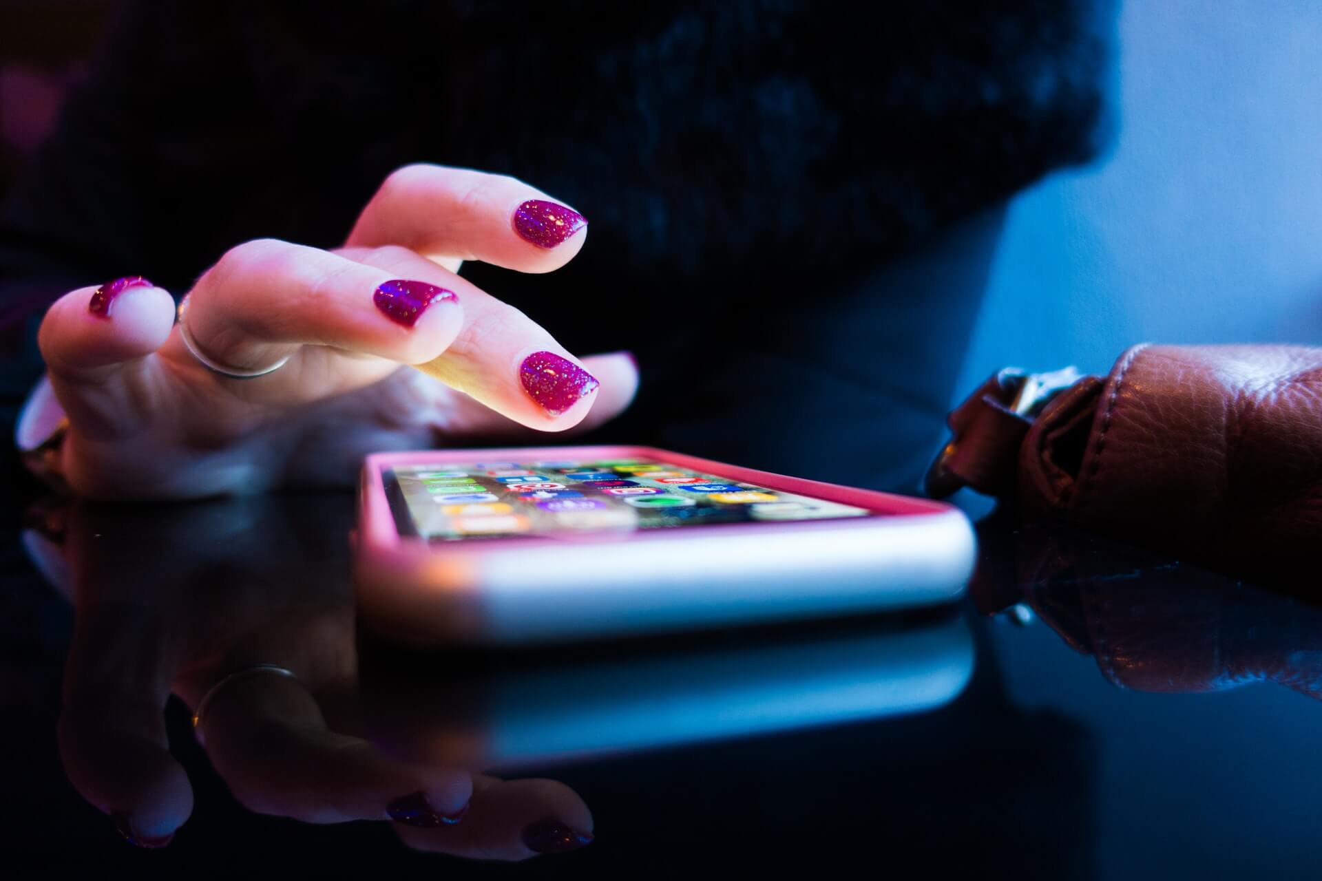 Kobieca ręka klikająca ikony na smartfonie