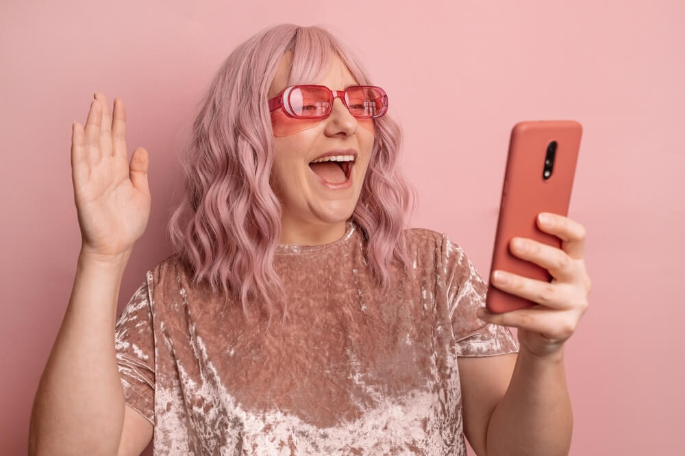 Kobieta w różowych włosach, robiąca sobie selfie.